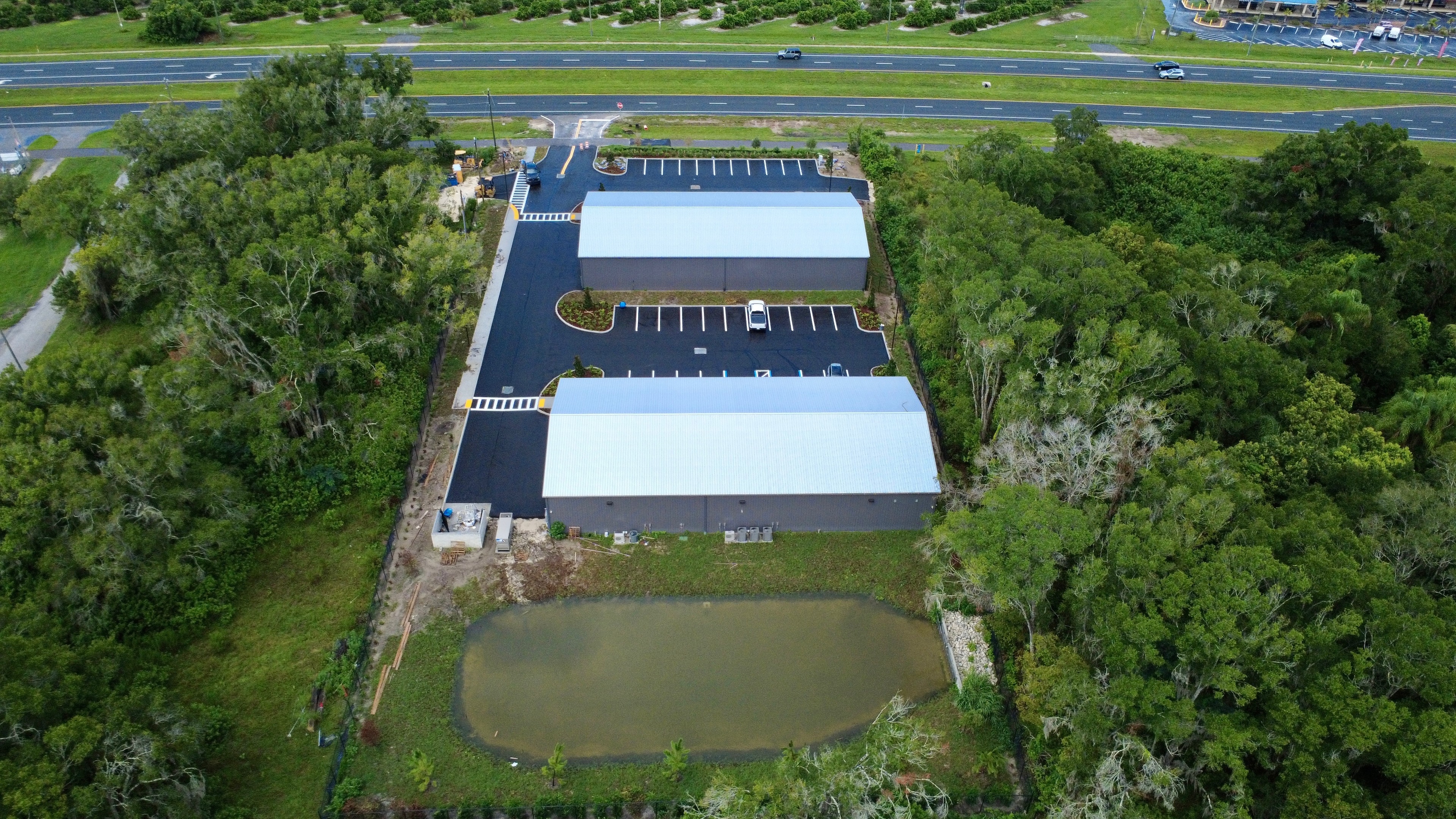 Aerial view of commercial facility with retention pond
